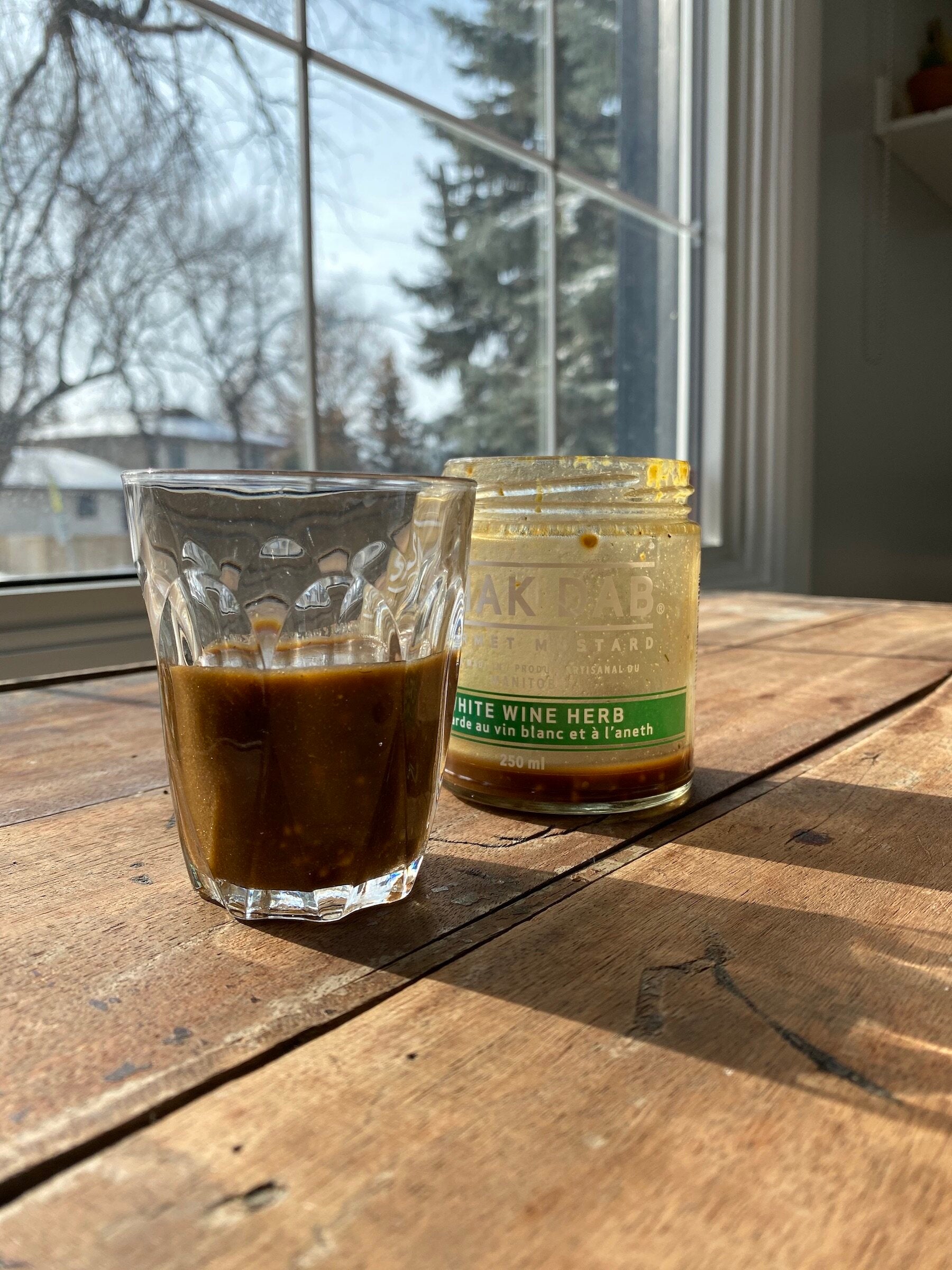 Mustard Jar Salad Dressing being shown in a glass cup