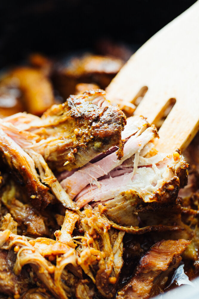 Pulled Pork being pulled apart with a wooden fork