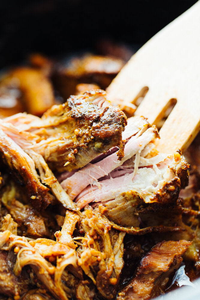 Pulled Pork being pulled apart with a wooden fork