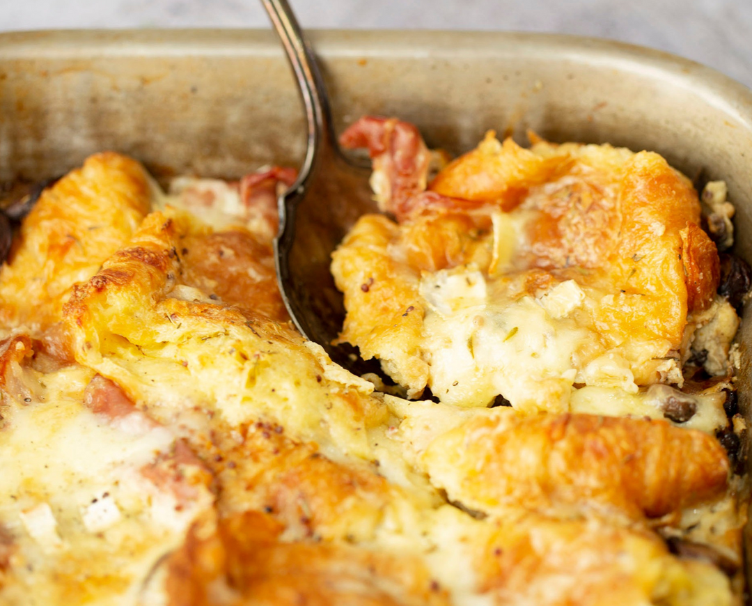 Ham & Cheese Croissant Bake being spooned into