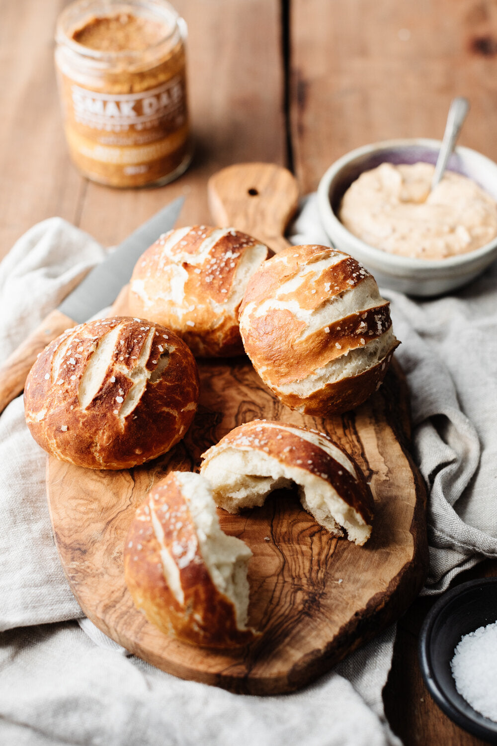 Soft Pretzel Rolls with Cheddar Mustard Cheese Sauce on a wooden board