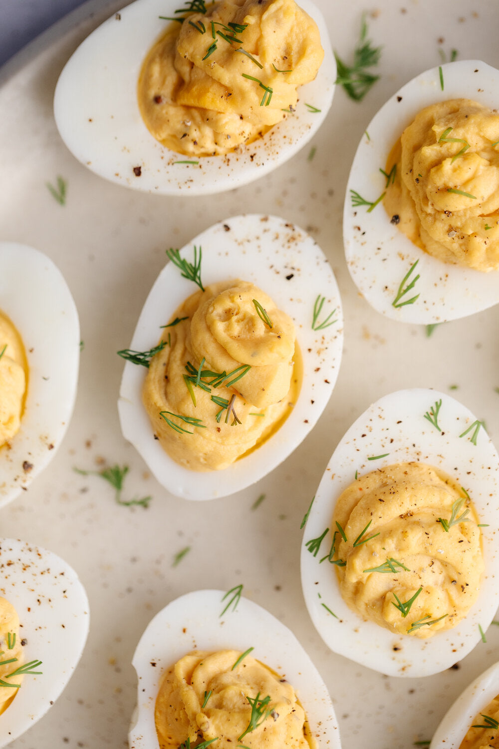 7 Smak Dab Devilled Eggs on a white plate topped with fresh parsley