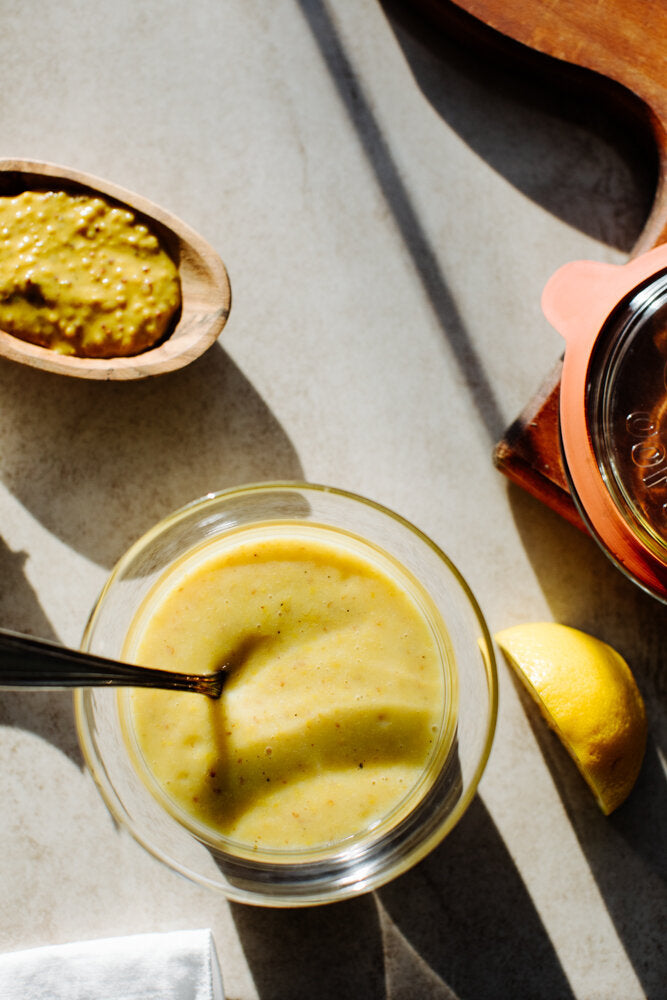 Honey Mustard Dressing in a glass bowl with a silver spoon in it