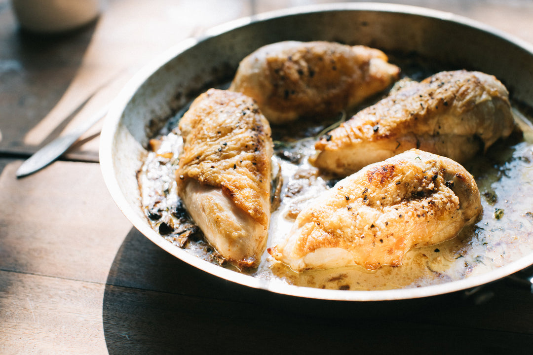 Chicken breasts in a white wine cream sauce in a silver cooking pan