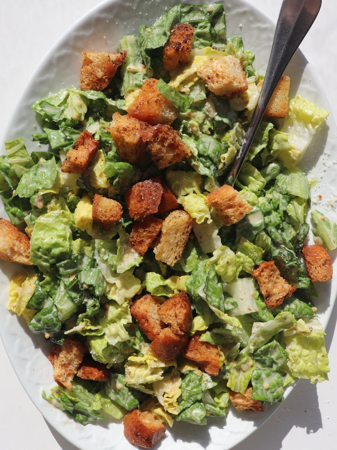 An upclose image of a salad with Staple Smak Dab Caesar Dressing