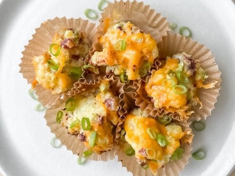 A plate of Henrik’s Loaded Baked Potato Cups in parchment cupcake liners