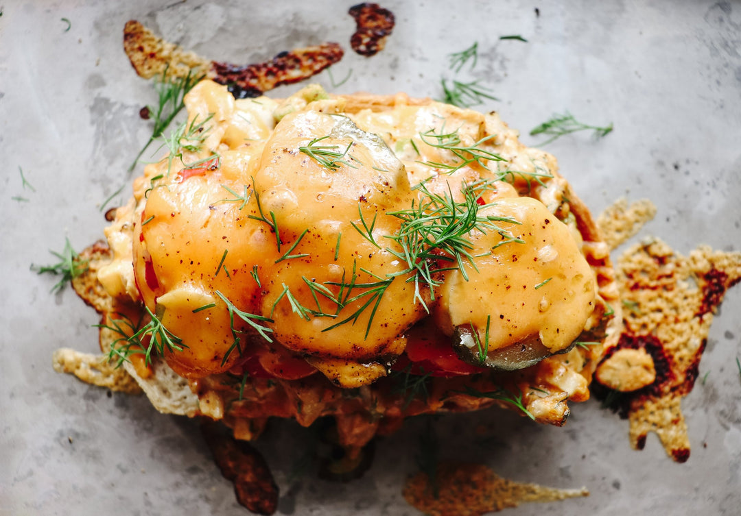Baked Buffalo Turkey Melt on a silver pan topped with fresh dill
