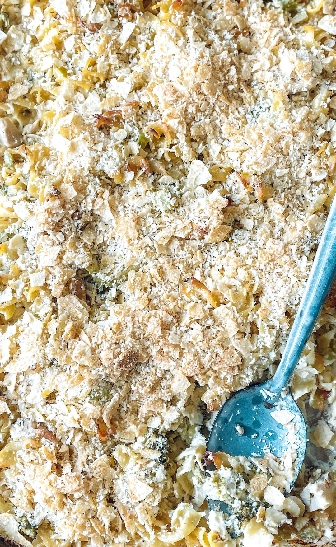A One Pan Turkey, Broccoli & Cheddar Noodle Bake with a silver serving spoon inserted