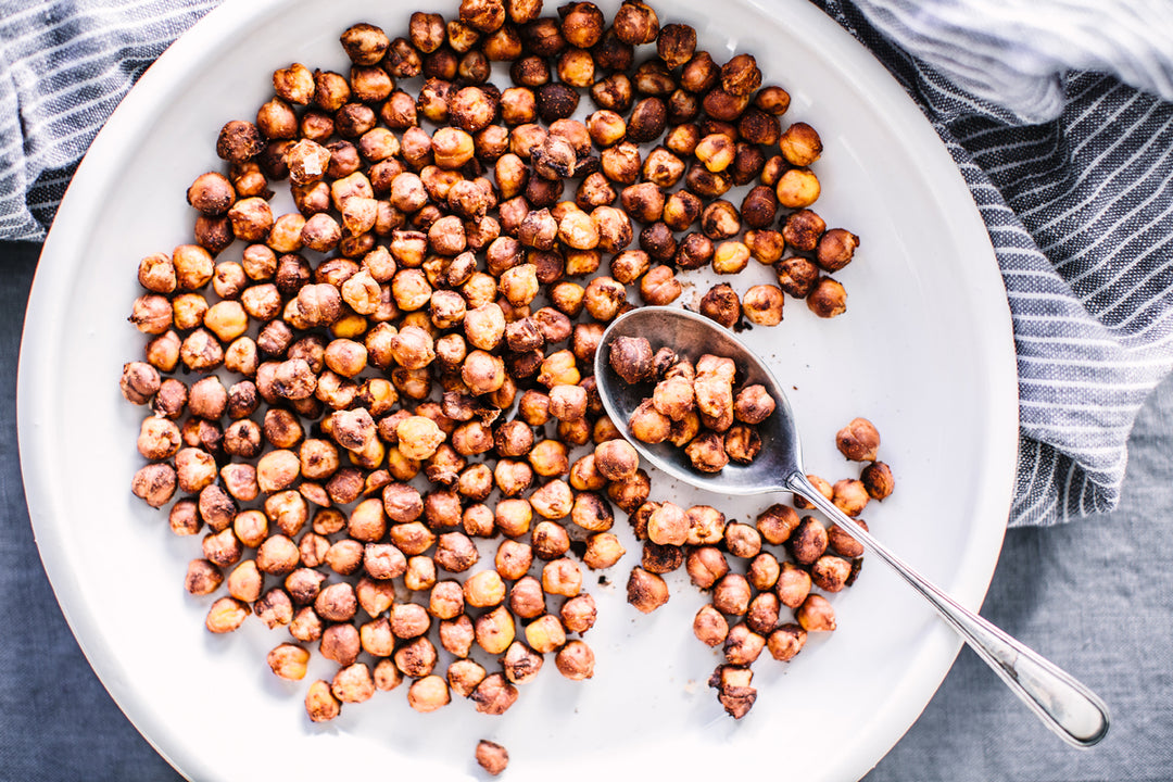 Crispy Dijon Chickpeas in a white bowl being scooped with a silver spoon